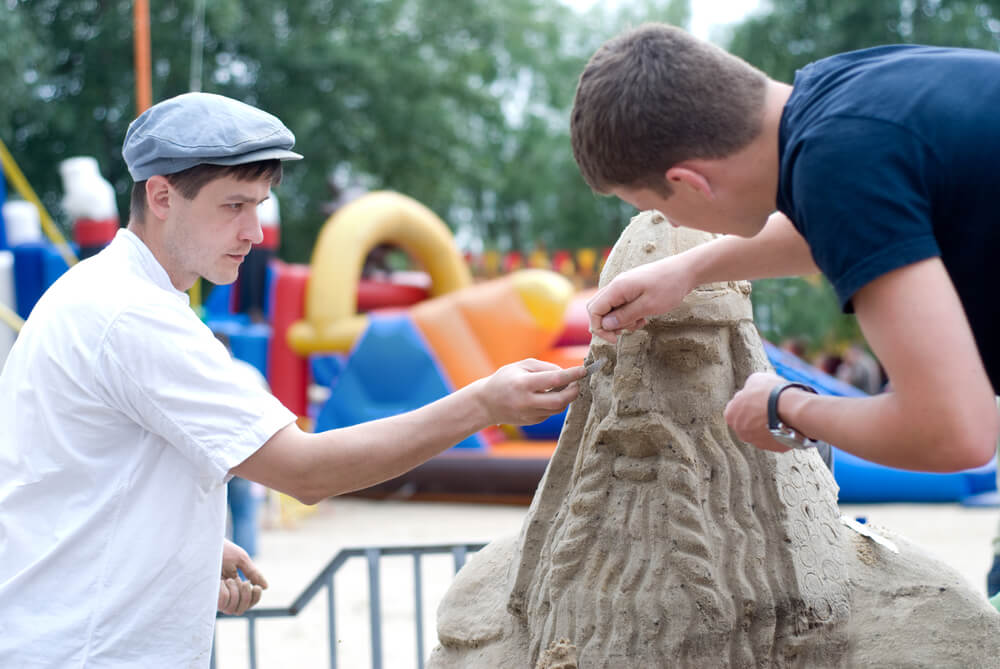 Two men working on a sand sculpture at one of the top Ocean Shores events.