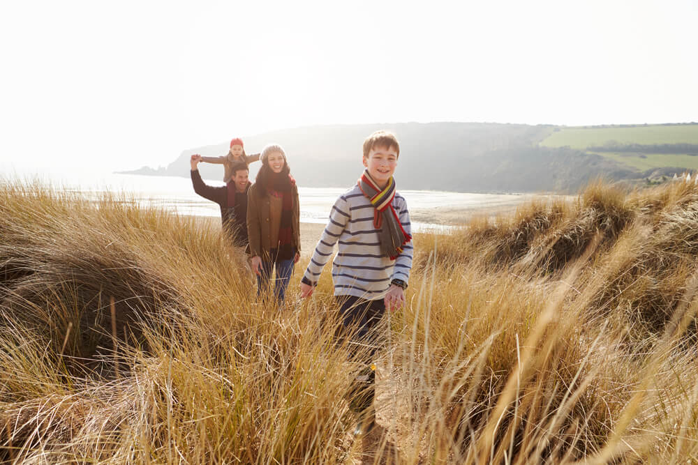 A family hiking on an Ocean Shores trail during their Washington winter vacation.