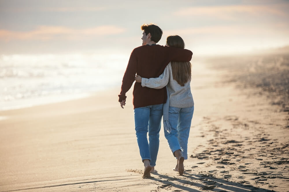 A couple walking along the beach during a romantic Valentine's getaway to Ocean Shores, Washington.