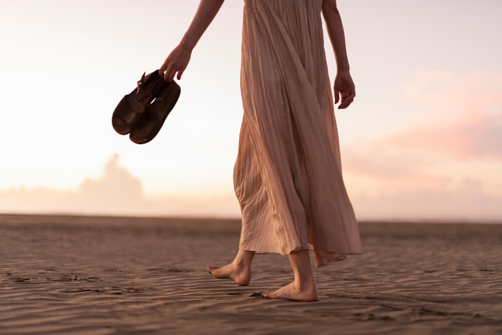 A woman going for a solo sunset beach walk, one of the best things to do in Ocean Shores in the summer.